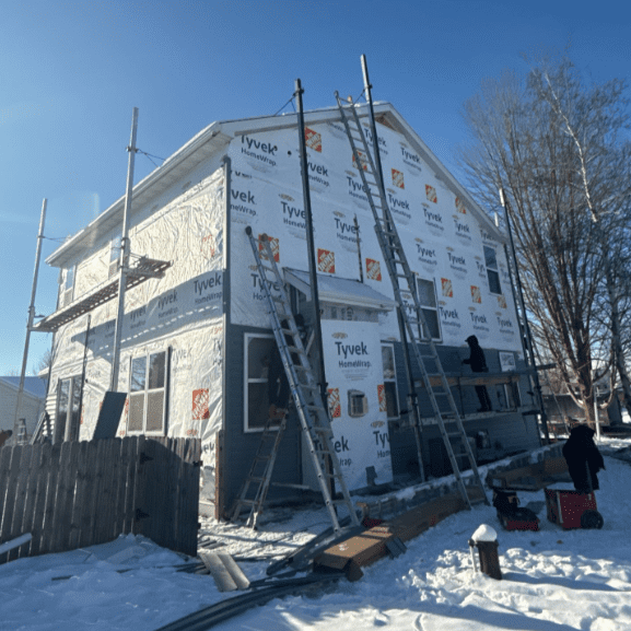 Modern Exterior crew installing new LP SmartSide siding over Tyvek-wrapped exterior during hail damage renovation in Ixonia, WI.