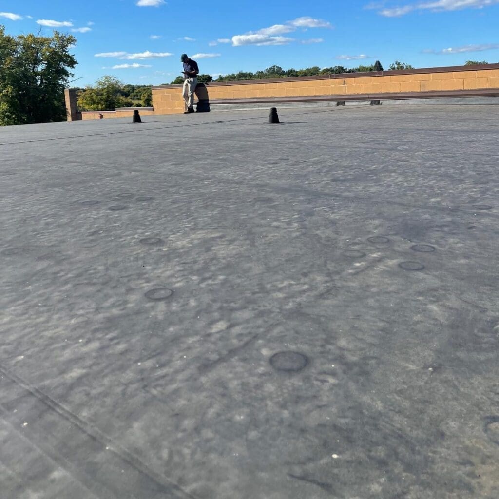 Modern Exterior completed EPDM flat roof installation with fully adhered membrane and sealed penetrations on commercial building