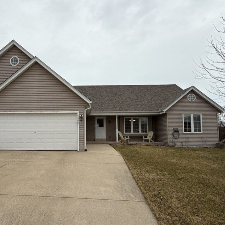 Front view of Oak Creek home before exterior renovation showing outdated siding, minimal trim detail, and no stone accent