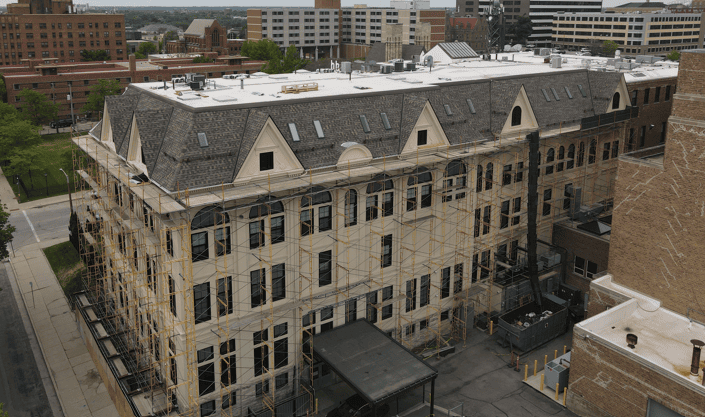 Scaffolding and fall protection installed for safe access during a large-scale commercial roof replacement in Milwaukee.